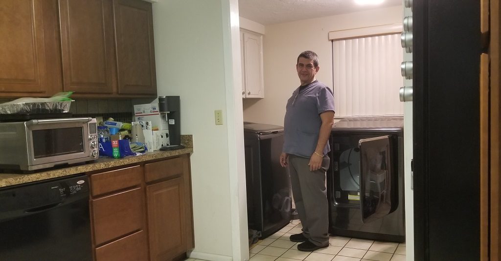 Rafael smiling while standing in the laundry room.